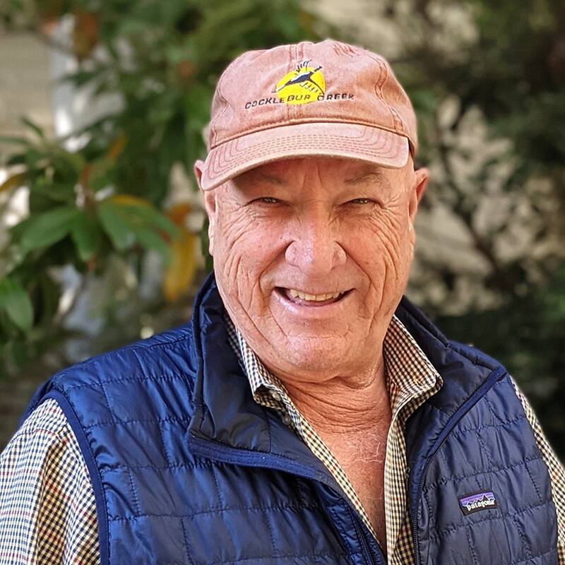 Don Westbrook, founder of C2 Equine, wearing vest and ballcap and smiling at camera.